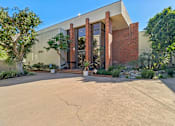 Thumbnail 31 of 32 - A modern building with a large front door and a brick facade.
