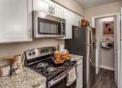 Thumbnail 26 of 34 - A kitchen with a black refrigerator and stove.