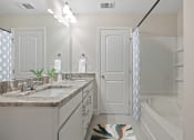 Thumbnail 4 of 28 - Omnia at Richmond Hill Townhomes in Georgia photo of a bathroom with a sink and a tub and a shower.