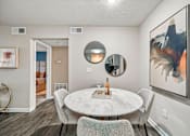 Thumbnail 6 of 34 - A modern dining room with a white table and chairs.
