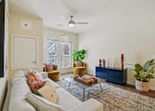 Thumbnail 6 of 39 - A living room with a white couch and a rug.
