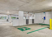 Thumbnail 28 of 31 - A parking garage with a green electric vehicle charging station.