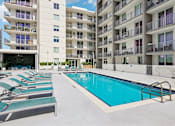 Thumbnail 12 of 31 - A swimming pool in front of apartment buildings.