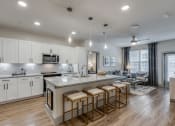 Thumbnail 2 of 34 - a kitchen and living room with an island and stools