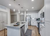 Thumbnail 11 of 34 - a large kitchen with white cabinets and stainless steel appliances