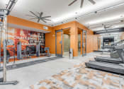 Thumbnail 13 of 34 - a gym with cardio equipment and a wall with a quote on it