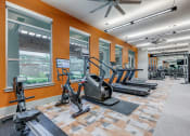 Thumbnail 21 of 34 - a gym with treadmills and other exercise equipment in the lobby of a building