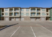 Thumbnail 23 of 34 - an empty parking lot in front of an apartment building