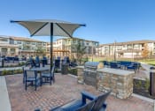 Thumbnail 29 of 34 - a patio with a grill and tables with chairs and umbrellas