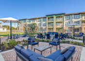 Thumbnail 30 of 34 - an outdoor lounge area with tables and chairs at the preserve at polk apartments