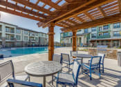 Thumbnail 31 of 34 - a patio with tables and chairs next to a swimming pool