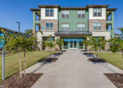 Thumbnail 33 of 34 - a large building with a sidewalk and trees in front of it