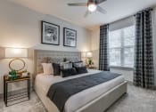 Thumbnail 8 of 34 - a bedroom with a large bed and a ceiling fan
