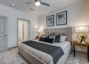 Thumbnail 9 of 34 - a bedroom with a large bed and a ceiling fan