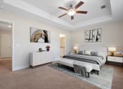 Thumbnail 3 of 28 - Omnia at Richmond Hill Townhomes in Georgia photo of a spacious bedroom with a bed and a ceiling fan.