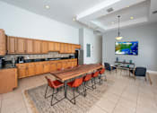 Thumbnail 21 of 28 - A modern kitchen with a dining table and chairs.