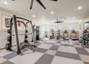 Thumbnail 38 of 56 - a home gym with exercise equipment and a ceiling fan