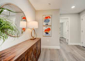 Thumbnail 7 of 29 - Lady Lake, FL Rentals – The Groves at Lake Ella - a hallway with a mirror and a wooden dresser with a plant