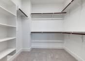 Thumbnail 11 of 19 - an empty walk in closet with white walls and shelves