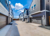 Thumbnail 16 of 19 - a row of townhomes with a blue sky in the background
