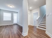 Thumbnail 8 of 19 - an empty living room with wood flooring and a staircase