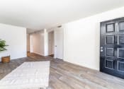 Thumbnail 8 of 17 - a living room with a black door and a rug