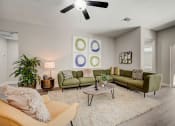 Thumbnail 8 of 29 - Pet-Friendly Rentals in Lady Lake, FL – The Groves at Lake Ella - an open living room with couches and chairs and a ceiling fan