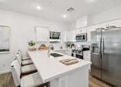 Thumbnail 4 of 45 - A modern kitchen with a white countertop and stainless steel appliances.