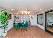 Thumbnail 18 of 34 - a dining room with a table and chairs and a kitchen with a plant