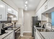 Thumbnail 1 of 17 - Pet-Friendly Apartments in Houston, TX – Artisan West – A kitchen with a stove, refrigerator, and sink.