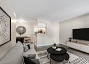 Thumbnail 7 of 17 - Pet-Friendly Apartments in Houston, TX – Artisan West – A living room with a grey couch, a black coffee table, and a television on the wall.