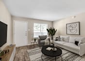 Thumbnail 6 of 17 - Modern Apartments in Houston, TX for Rent- Artisan West-  A living room with a white couch, a black coffee table, and a large painting on the wall.
