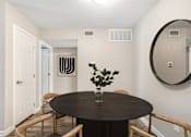 Thumbnail 5 of 17 - Pet-Friendly Apartments in Houston, TX – Artisan West – A round table with a vase of flowers on it sits in a room with a mirror and a door.