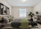 Thumbnail 10 of 17 - Pet-Friendly Apartments in Houston, TX – Artisan West – A bedroom with a bed, a green blanket, and a potted plant.