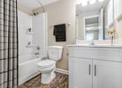 Thumbnail 9 of 17 - Modern Apartments in Houston, TX for Rent- Artisan West-  A white toilet sits in a bathroom next to a white sink.