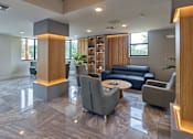 Thumbnail 24 of 36 - Gateway Luxury Apartments club room showcasing stylish seating arrangements and ambient lighting.