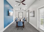 Thumbnail 35 of 40 - A dining room with a blue wall and a ceiling fan.