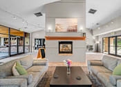 Thumbnail 42 of 47 - A living room with a fireplace and two grey couches.