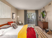 Thumbnail 28 of 34 - A bedroom with a large bed and a window with curtains.