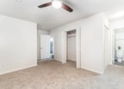 Thumbnail 9 of 20 - an empty living room with a ceiling fan and a bathroom