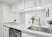 Thumbnail 3 of 34 - A kitchen with a granite countertop and stainless steel appliances.