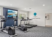 Thumbnail 27 of 40 - A fitness center with treadmills and elliptical machines.