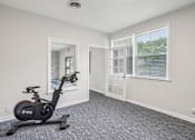 Thumbnail 29 of 40 - A room with a stationary bike in it.