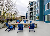 Thumbnail 15 of 16 - A patio with blue chairs and a table.