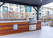 Thumbnail 12 of 16 - A BBQ grill is on a wooden deck with a sign on it.