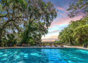 Thumbnail 4 of 11 - a swimming pool with a colorful sky in the background