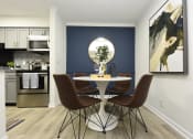Thumbnail 6 of 27 - a dining room with a table and chairs and a blue accent wall