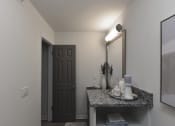Thumbnail 15 of 27 - a bathroom with a sink and a mirror and a door