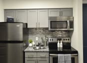 Thumbnail 1 of 27 - a kitchen with stainless steel appliances and a granite counter top