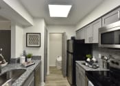 Thumbnail 5 of 27 - a kitchen with granite counter tops and a stainless steel refrigerator